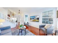 Bright living room boasts hardwood floors, neutral colors, and a large window for natural light at 1265 Iris Ct, Highlands Ranch, CO 80126