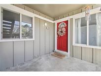 Inviting condo front door features a vibrant red door, seasonal wreath, and a charming welcome mat at 857 S Van Gordon Ct # B107, Lakewood, CO 80228
