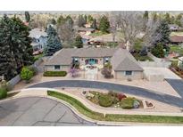 Sprawling single story home with circular driveway, lush landscaping, and mountain views at 2653 S Harrington Ln, Lakewood, CO 80227