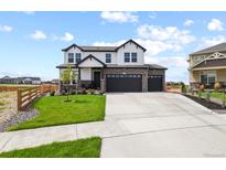 Beautiful two-story home boasting a three-car garage, stone accents, and a manicured lawn at 16002 E 111Th Cir, Commerce City, CO 80022