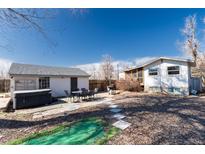 Large backyard with a patio, hot tub, detached garage, and lush green spaces at 3500 W 55Th Ave, Denver, CO 80221