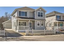 Charming two-story home with a welcoming front porch and a classic picket fence at 7998 E Vassar Dr, Denver, CO 80231