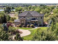 Stunning two-story home featuring stone accents, well-manicured landscaping, and a circular driveway, creating great curb appeal at 12648 Waterside Ln, Longmont, CO 80504