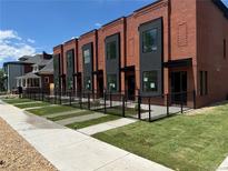 Modern townhomes featuring brick facades, black trim, and landscaping offering a contemporary urban living experience at 115 W 2Nd Ave # 101, Denver, CO 80223