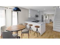 Modern kitchen featuring an island with seating, stainless steel appliances, and ample natural light at 115 W 2Nd Ave # 101, Denver, CO 80223