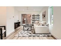 Bright living room featuring a modern sofa, stylish rug, and sliding glass door to the outside at 115 W 2Nd Ave # 101, Denver, CO 80223