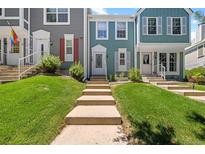 Charming blue two-story townhouse with white trim and well-maintained front lawn at 10567 W Dartmouth Ave, Lakewood, CO 80227