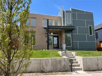 Contemporary home with a brick and gray exterior, green lawn, and a covered front entrance at 4351 Yates St, Denver, CO 80212