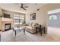 Inviting living room featuring a fireplace, neutral color palette and plush carpeting at 7440 S Blackhawk St # 4-102, Englewood, CO 80112
