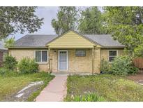 Charming single-story brick home with a covered porch, walkway, and mature trees in a quiet neighborhood at 1691 Poplar St, Denver, CO 80220