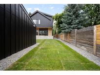 Beautifully landscaped backyard with a lush lawn and modern fence, perfect for outdoor entertaining and relaxation at 4238 Zuni St, Denver, CO 80211
