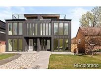 Modern two-story home with large windows, sleek lines, rooftop deck, and well-maintained landscaping at 4238 Zuni St, Denver, CO 80211