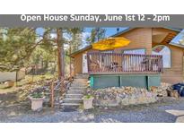 Charming cabin with a wooden deck, stone accents, and inviting steps leading to the front entrance at 11798 Ridge Rd, Golden, CO 80403