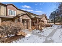 Charming townhome exterior features brick accents and a covered front porch, enhancing curb appeal at 6480 Silver Mesa Dr # B, Highlands Ranch, CO 80130