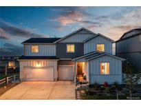 Charming two-story home features a two-car garage, landscaped front yard, and inviting entrance at twilight at 17851 Herrera Dr, Parker, CO 80134