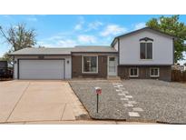 Charming split-level home featuring a brick facade, light blue siding, and a well-maintained front yard at 2493 S Kalispell Cir, Aurora, CO 80013