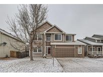 Charming two-story home with a well-maintained lawn and attached garage and beautiful snow covered front yard at 560 Hampstead Ave, Castle Rock, CO 80104