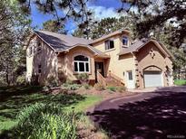 Inviting two-story home featuring a charming exterior, well-manicured landscaping, and a driveway leading to an attached garage at 19850 Indian Summer Ln, Monument, CO 80132