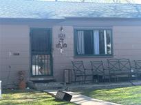 A single-story home has a secure door and seating area on the front porch at 1840 W Arkansas Ave, Denver, CO 80223