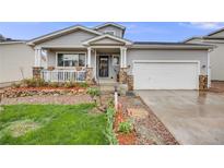 Charming home with a welcoming porch, stone accents, lovely landscaping and a well-maintained lawn at 9674 Fox Den Dr, Littleton, CO 80125