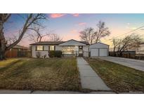 Charming single-story home with a detached two-car garage and a well-maintained front yard and walkway at 555 Everett St, Lakewood, CO 80226