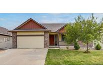 Charming single-Gathering home featuring a well-maintained lawn, two-car garage, and a welcoming front porch at 5770 Waverley Ave, Firestone, CO 80504