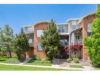 Charming townhome with brick and grey facade, featuring well-maintained landscaping and private balconies at 84 Spruce St # 707, Denver, CO 80230