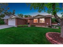 Charming brick home with a lush, green lawn and well-maintained landscaping at 12906 Cherry Way, Thornton, CO 80241