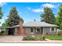 Charming single-story home featuring a brick chimney, a well-kept lawn, and beautiful landscaping at 6755 W 45Th Ave, Wheat Ridge, CO 80033