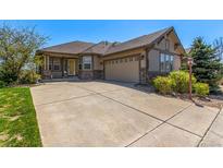 Charming single-Gathering home showcasing a well-manicured lawn and an inviting facade with stone accents at 7580 S Biloxi Ct, Aurora, CO 80016