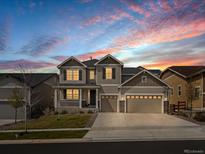 Charming two-story home with a three-car garage, covered porch, and professional landscaping at 13041 Reata Ridge Dr, Parker, CO 80134