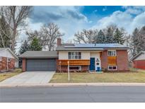 Charming front exterior with brick and wood siding, a blue door, and solar panels at 2641 S Magnolia St, Denver, CO 80224