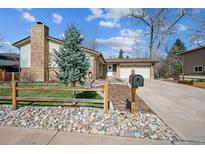Charming single-Gathering home with brick accents, a two-car garage, and lush front yard landscaping at 4447 E Lake S Cir, Centennial, CO 80121