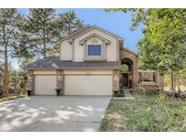 Charming two-story home with a three car garage, brick accents, manicured lawn and mature trees at 25875 Buffalo Ln, Golden, CO 80401