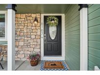 Charming front door with stone accents, decorative wreath and vibrant potted plants for a welcoming entrance at 6167 S Pierson St, Littleton, CO 80127