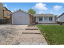 Charming single Gathering home with brick accents, well-manicured lawn, and inviting walkway at 18714 E Utah Cir, Aurora, CO 80017