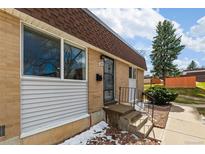 Charming brick home with a secure gated entrance and manicured rock landscaping at 12893 W Alameda Dr, Lakewood, CO 80228