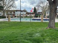 Community pool view in a well-maintained neighborhood with lawn and landscaping at 12893 W Alameda Dr, Lakewood, CO 80228