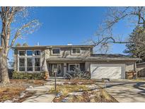 Two-story house with a white garage door and landscaped yard at 5760 S Geneva St, Greenwood Village, CO 80111