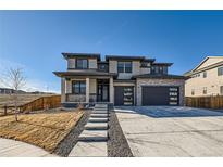 Striking two-story home featuring a modern design, stone accents, and a well-manicured front yard at 14209 Beebalm Loop, Parker, CO 80134
