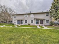 Townhome exterior featuring well-maintained lawns, light gray siding, and inviting front entrances at 1932 S Oswego Way, Aurora, CO 80014