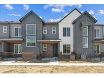 Modern townhome featuring large windows and neutral gray and white siding at 6902 Huddersfield Ln, Castle Pines, CO 80108