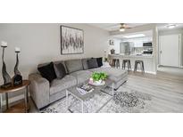 Comfortable living room features a large gray couch, modern decor, and an open view to the kitchen at 4274 S Salida Way # 6, Aurora, CO 80013