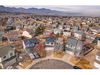 Bright aerial view of a home in a neighborhood with mountain views and mature trees at 9593 Racoon Pl, Littleton, CO 80125