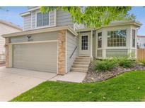 Charming two-story home featuring an attached garage, manicured lawn, and brick accents at 10535 Holyoke Dr, Parker, CO 80134