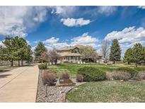 Beautiful home featuring lush landscaping, mature trees, and a circular driveway at 1289 Diamond Ridge Cir, Castle Rock, CO 80108