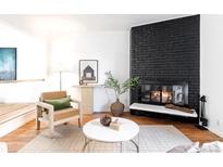 Bright living room featuring a striking black brick fireplace, comfortable seating and neutral décor at 3855 S Monaco Pkwy # 106, Denver, CO 80237