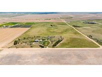 Expansive aerial view of the home on a large lot with surrounding farmland and blue sky at 4100 Eclectic St, Watkins, CO 80137