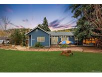 Charming single Gathering home with a beautiful lawn, garden, and stone patio at 26095 Columbine Trl, Kittredge, CO 80457
