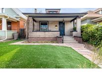 Charming brick home featuring a well-manicured lawn and covered front porch at 3445 N Clay St, Denver, CO 80211